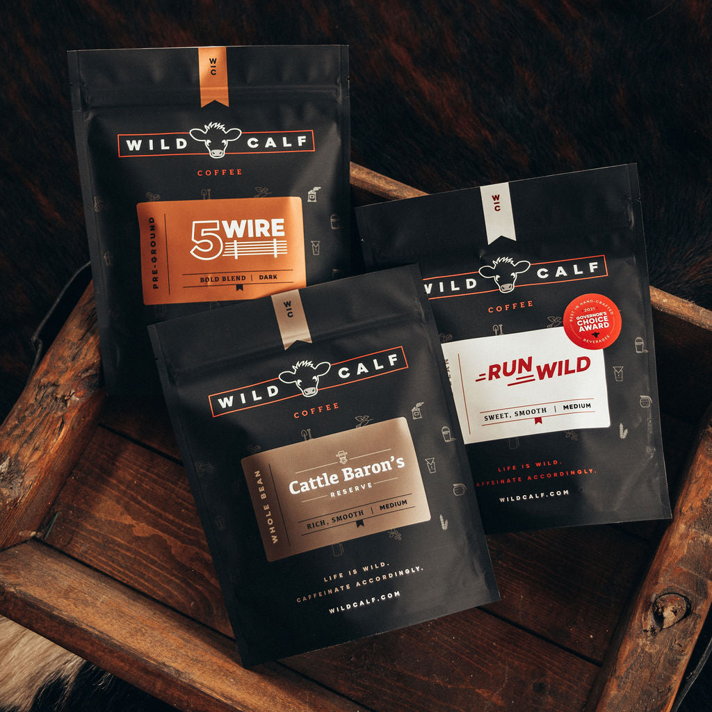 Run Wild, 5 Wire, and Cattle Baron's Reserve coffee bags arranged on a wooden tray